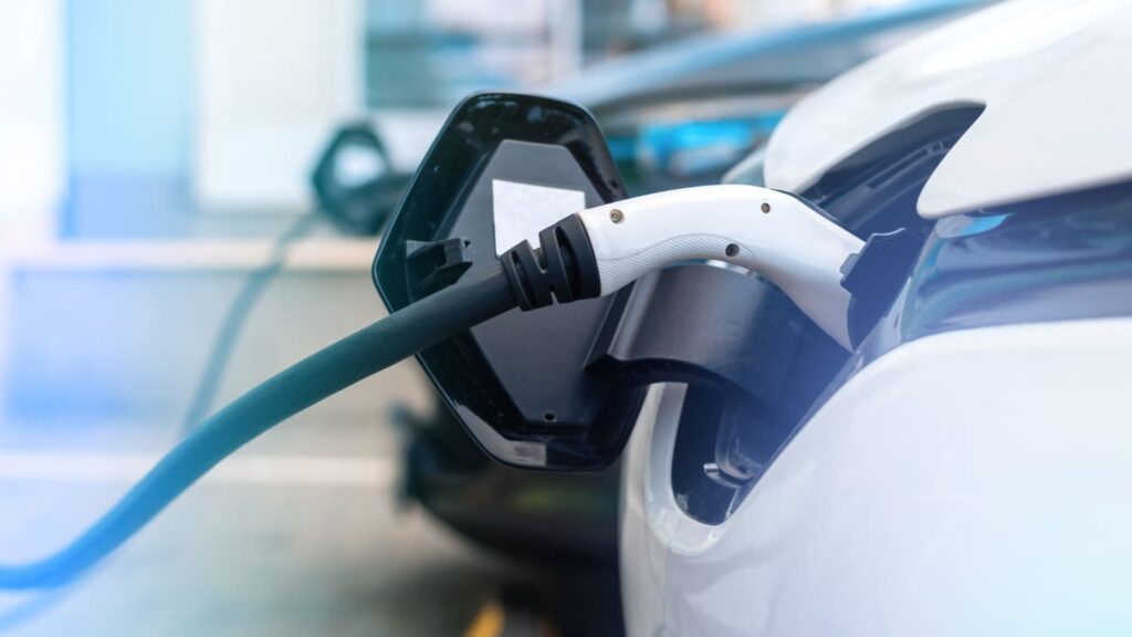 Laadkabel verbonden met witte elektrische auto tijdens het opladen, focus op bijtelling elektrische auto