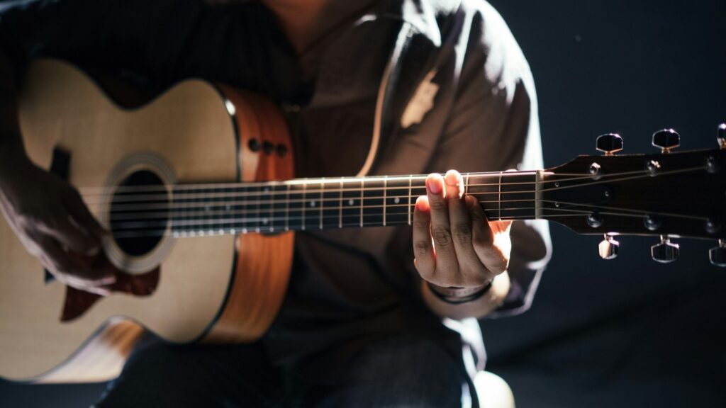 Gitaarakkoorden leren op akoestische gitaar met close-up van handpositie op de hals