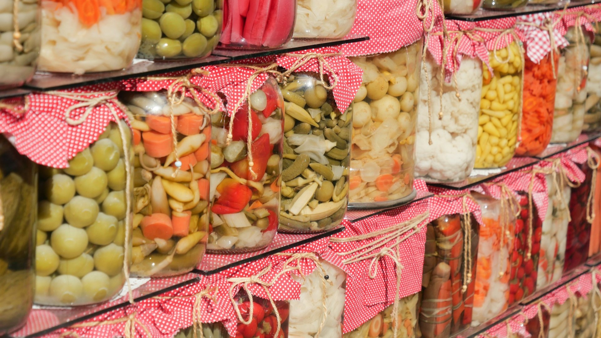 Potten met gefermenteerde groenten zoals wortel, kool en augurk tijdens fermenteren op een plank