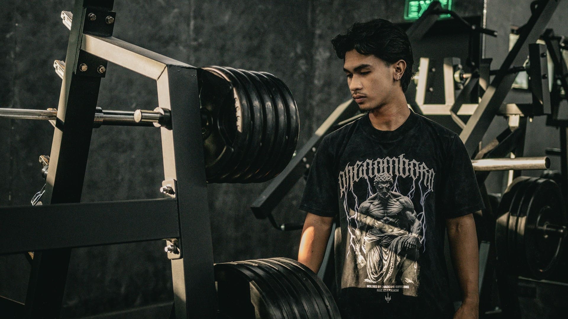 Man in gym bij zwaar beladen halterstang in krachtopstelling omgeving