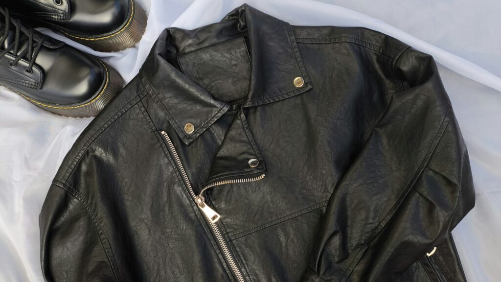 Zwarte leren jas met rits en laarzen, passend bij zorgvuldig jas onderhouden per materiaalsoort