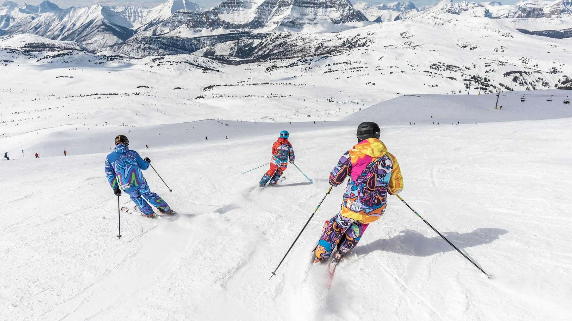 Skidag met drie skiërs in gecontroleerde afdaling op brede berghelling
