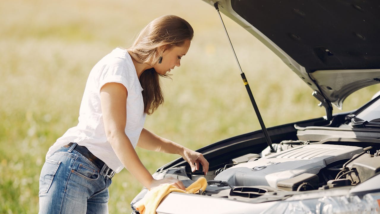 Autopech veilig handelen terwijl bestuurder motor controleert bij geparkeerde auto in veilige omgeving