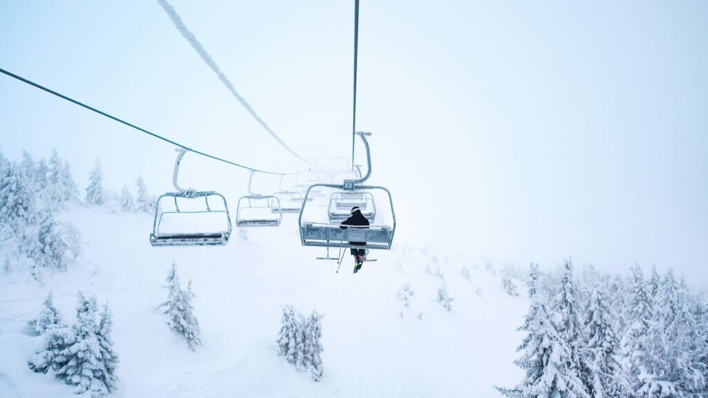Skidag met rustige lift omhoog boven besneeuwd berglandschap in winterse mist